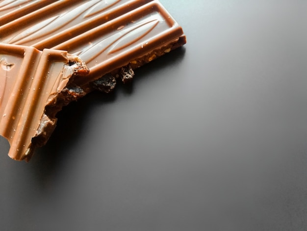 Bar of milk chocolate with crushed hazelnut and alcohol raisins isolated