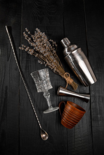 Bar shaker and flowers at black background