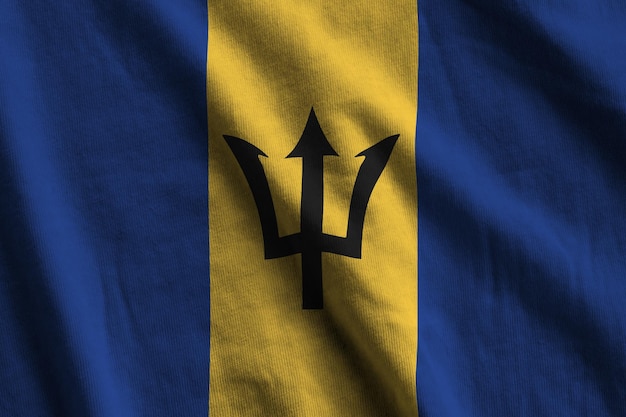 Barbados flag with big folds waving close up under the studio light indoors The official symbols and colors in banner