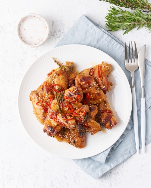 Barbecue chicken wings. Oven baked chiken on plate in red sauce. Hot asian food. Top view