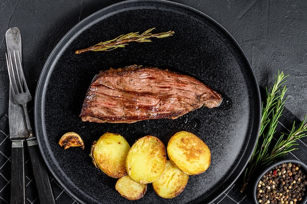 Barbecue dry aged wagyu flank steak.  Black background. Top view