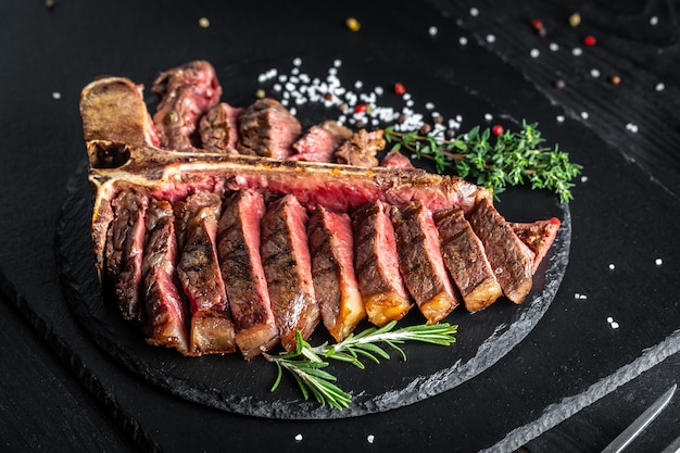 Barbecue dry aged Wagyu Porterhouse Steak sliced with green Asparagus on a cutting board