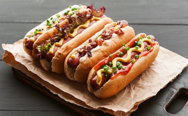 Barbecue Grilled Hot Dogs with  yellow American mustard, On a dark wooden background