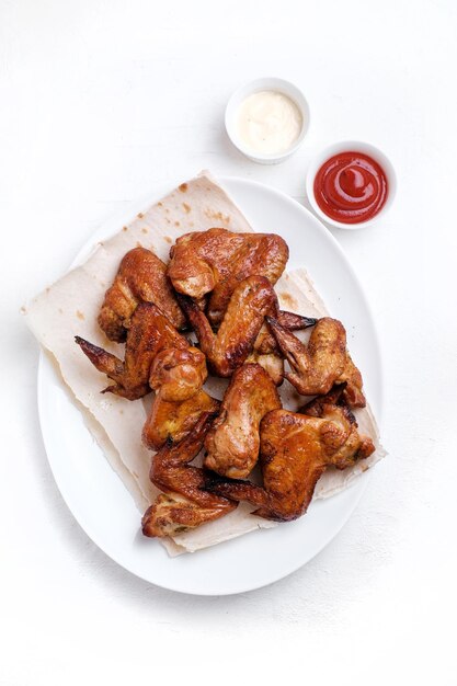 Barbecue hot chicken wings on wooden table Top view