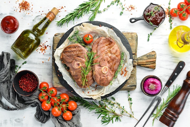 Barbecue Lamb steak with spices and vegetables on a white wooden background Flat lay Top view