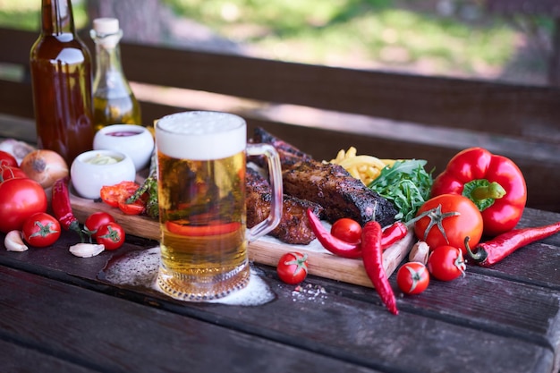 Barbecue pork ribs on wooden serving board on picnic table outdoors