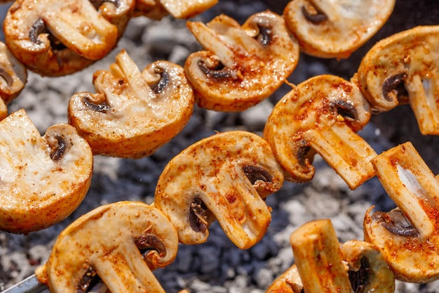 Barbecue skewers with delicious grilled champignon mushroom kebab in a brazier