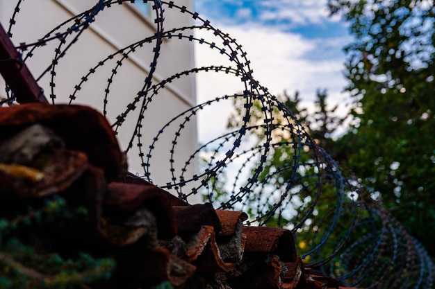 Barbed wire on an old fence with clay tiles