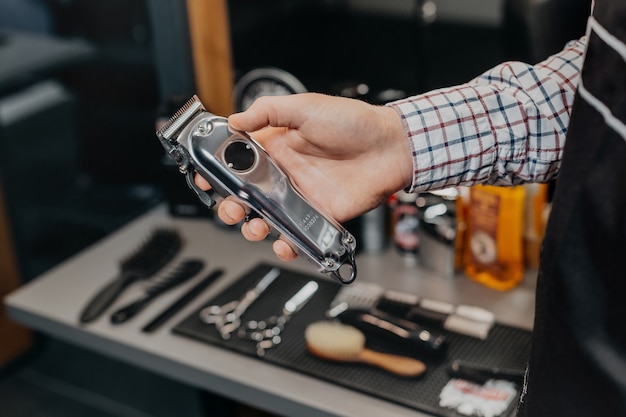 Barber holding electric razor at the barbershop