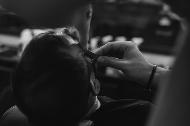 Barber makes a haircut to the client. Men's haircut in barbershop.