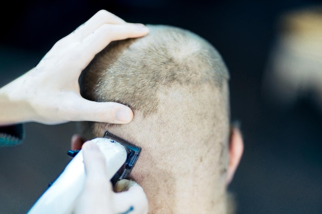 Barber's hands trimming hair of client's nape