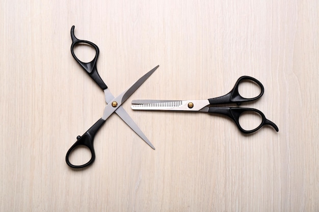 Barber set with two scissors on light wooden table