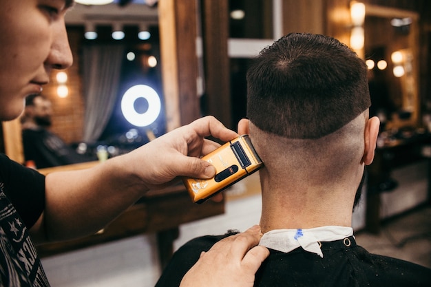 Barber shop, a man with a beard cut hairdresser. Professional haircut, retro hairstyle and styling. Beautiful hair and care, hair salon for men. Customer service. Russia, Sverdlovsk, February 12, 2018