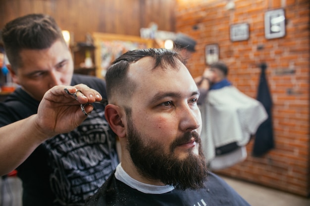 Barber shop, a man with a beard cut hairdresser