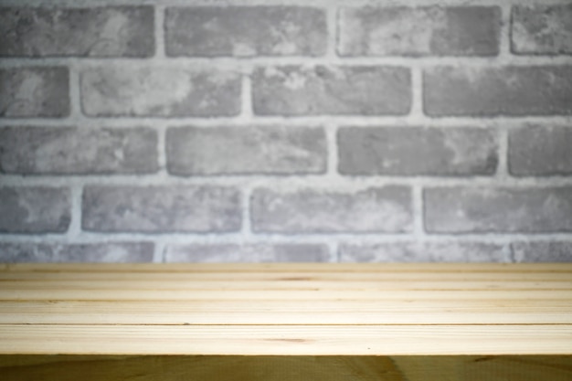 Bare cement wall in dark tone with pine wood table.