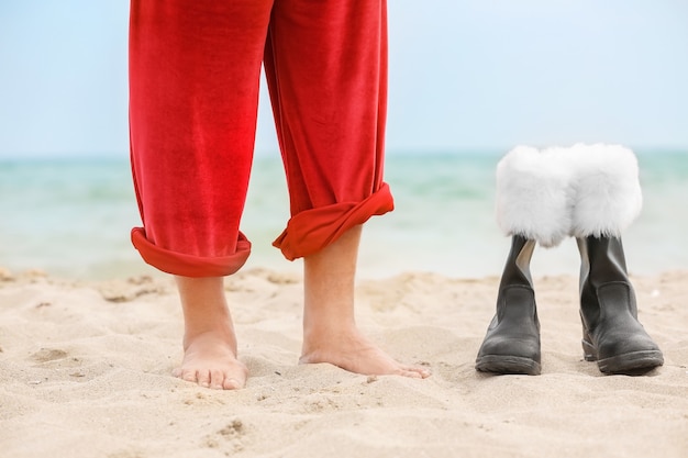 Barefoot Santa Claus and boots on beach