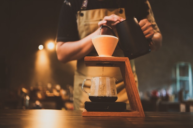 Barista brewing a coffee filter drip in the morning, beverage drink with fresh black espresso aroma, hot drink in cup of cafes, brown caffeine in bar shop background