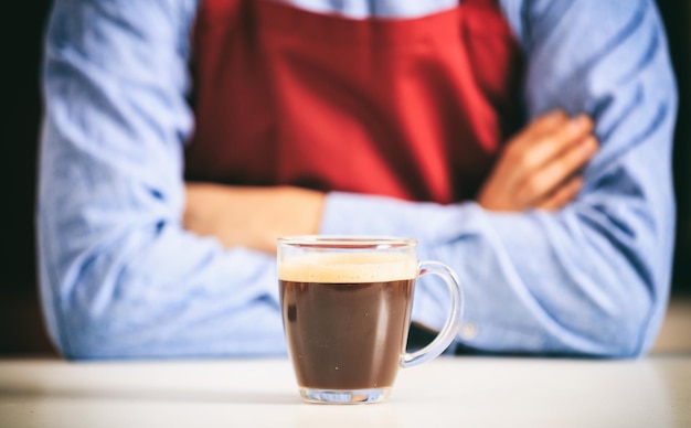 Barista in front of a cup of coffee