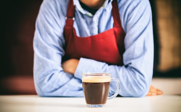 Barista in front of a cup of coffee