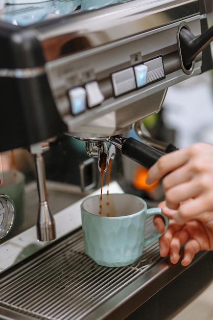 A barista girl pouring coffee from a coffee machine into a cup Cafe