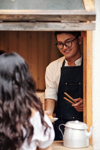 Barista Giving Order to Customer