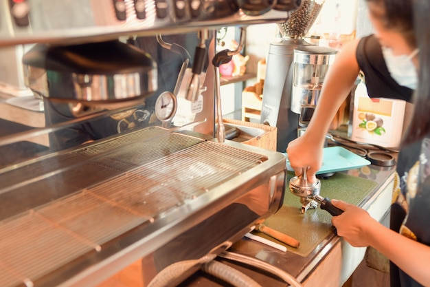 Barista make coffee latte art with espresso machine in cafe vintage color tone