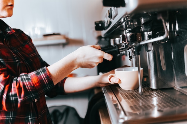 Barista makes aromatic coffee.