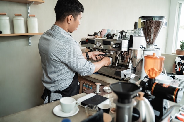 Barista makes coffee with a coffee maker machine