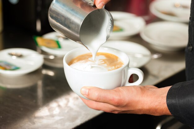 Barista making cappuccino in his coffeeshop