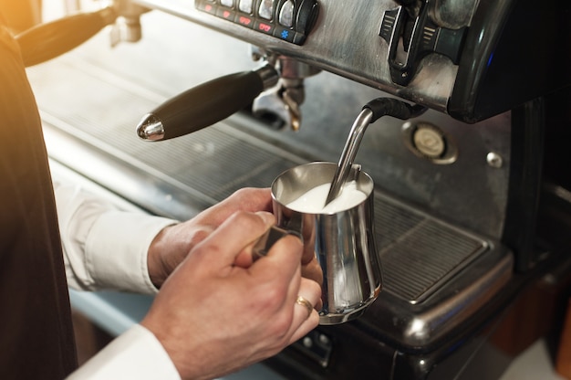 Barista making coffee. Preparing milk for cappuccino