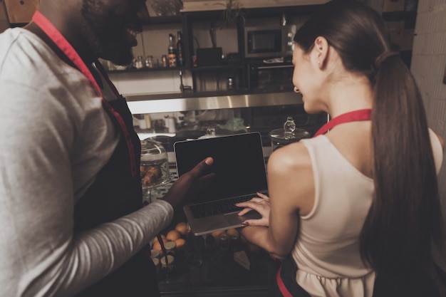 Barista man and woman looking at a laptop