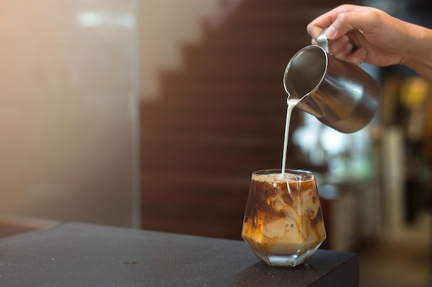 Barista pouring coffee in glass