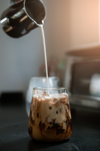 Barista pouring milk in glass