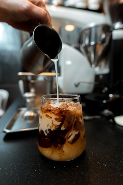 Barista pouring milk in glass