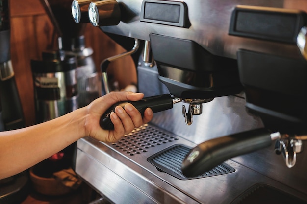 Barista prepares to make coffee with a coffee machine.