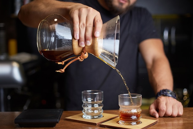 Barista preparing coffee using chemex pour over coffee maker