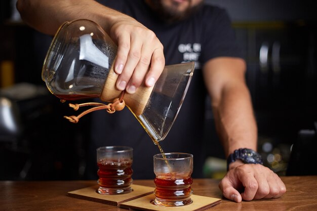 Barista preparing coffee using chemex pour over coffee maker