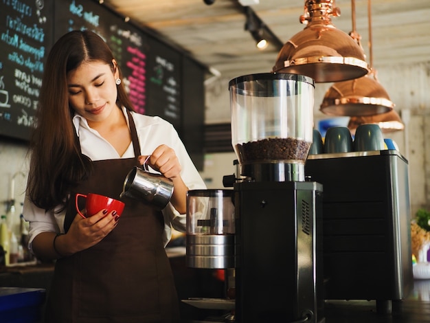 Barista woman making a coffee cup at cafe.