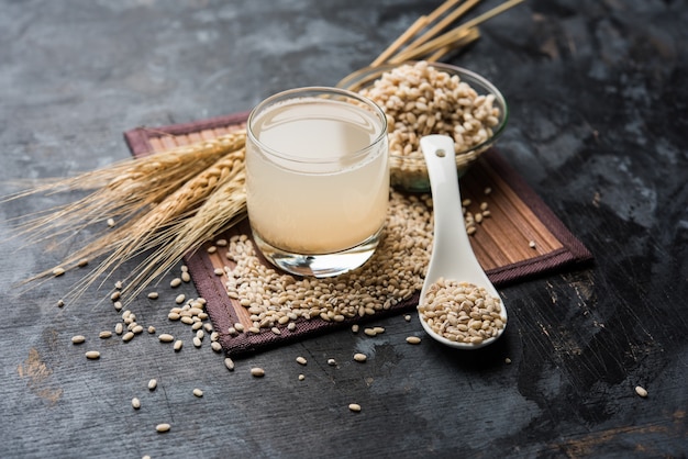 Barley water in glass with raw and cooked pearl barley wheat or seeds. selective focus