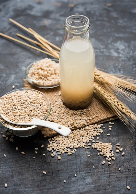 Barley water in glass with raw and cooked pearl barley wheat or seeds. selective focus