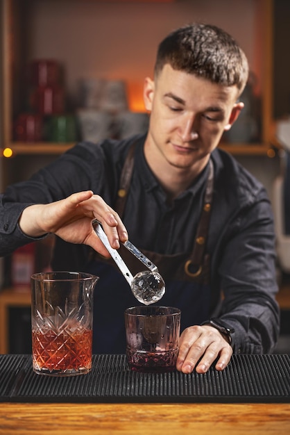 Barman putting ice ball