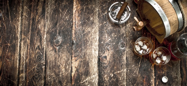 barrel of Scotch whiskey with a glass. On a wooden background.