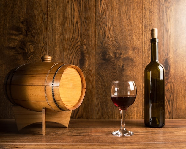 Barrel for wine and a bottle of wine with a glass