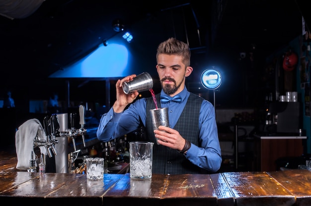 Bartender concocts a cocktail behind the bar