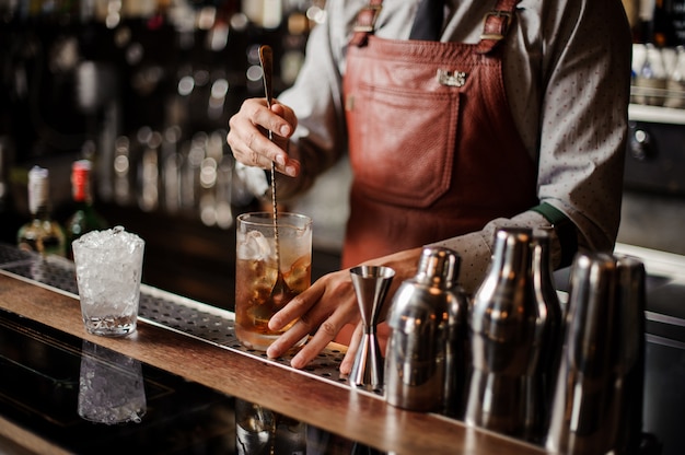 Bartender cooling out Cocktail glass mixing ice with a spoon