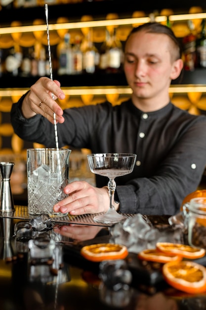 Bartender performing an alcoholic fresh red luxury cocktail at the bar Decorated with oranges