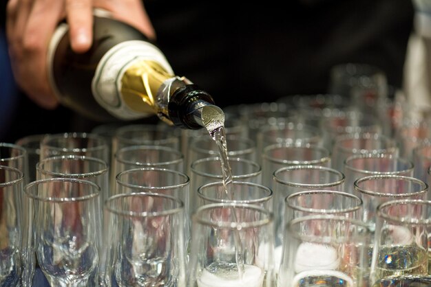 Photo bartender pouring champagne into glass