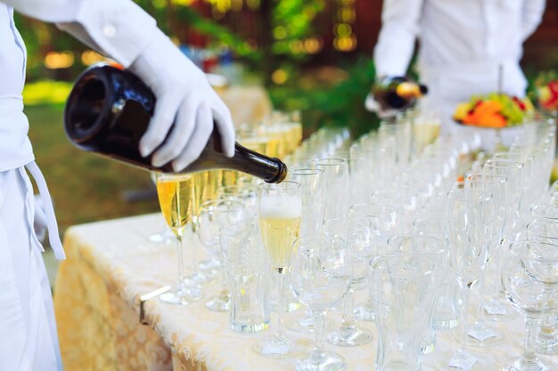 Bartender pouring champagne into glasses