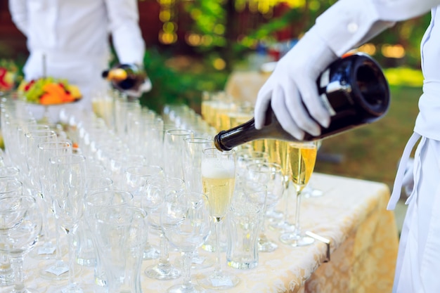 Bartender pouring champagne into glasses