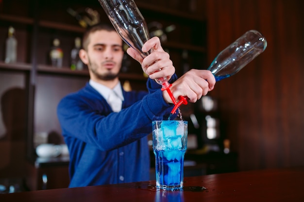 Bartender pouring fresh cocktail in fancy glass